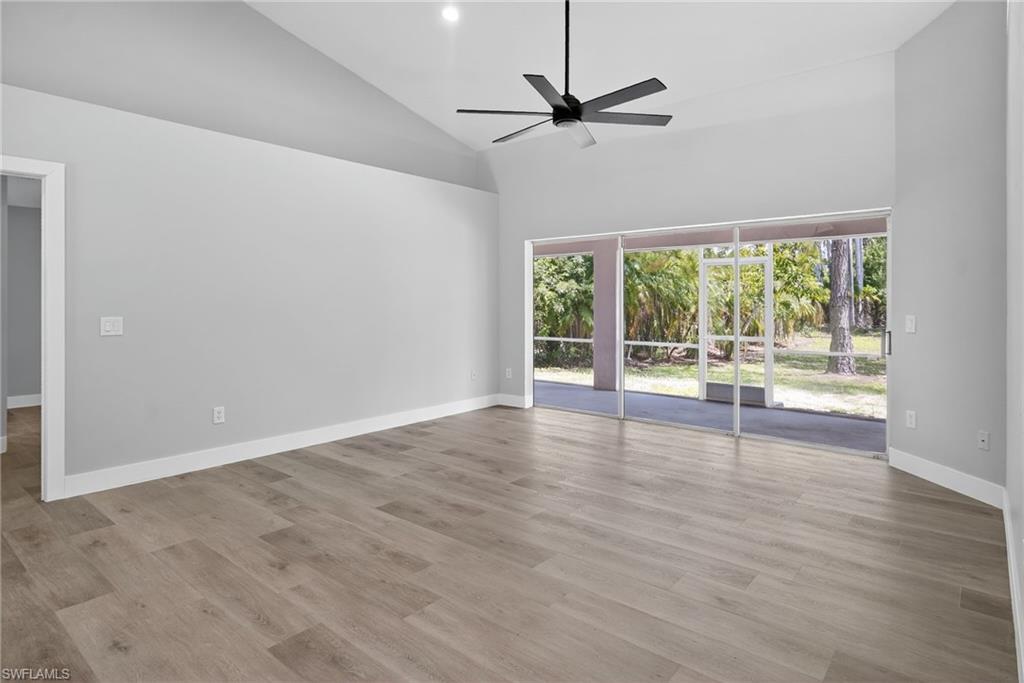 Living room with high vaulted ceiling, pocket sliding doors, ceiling fan, and recessed lighting