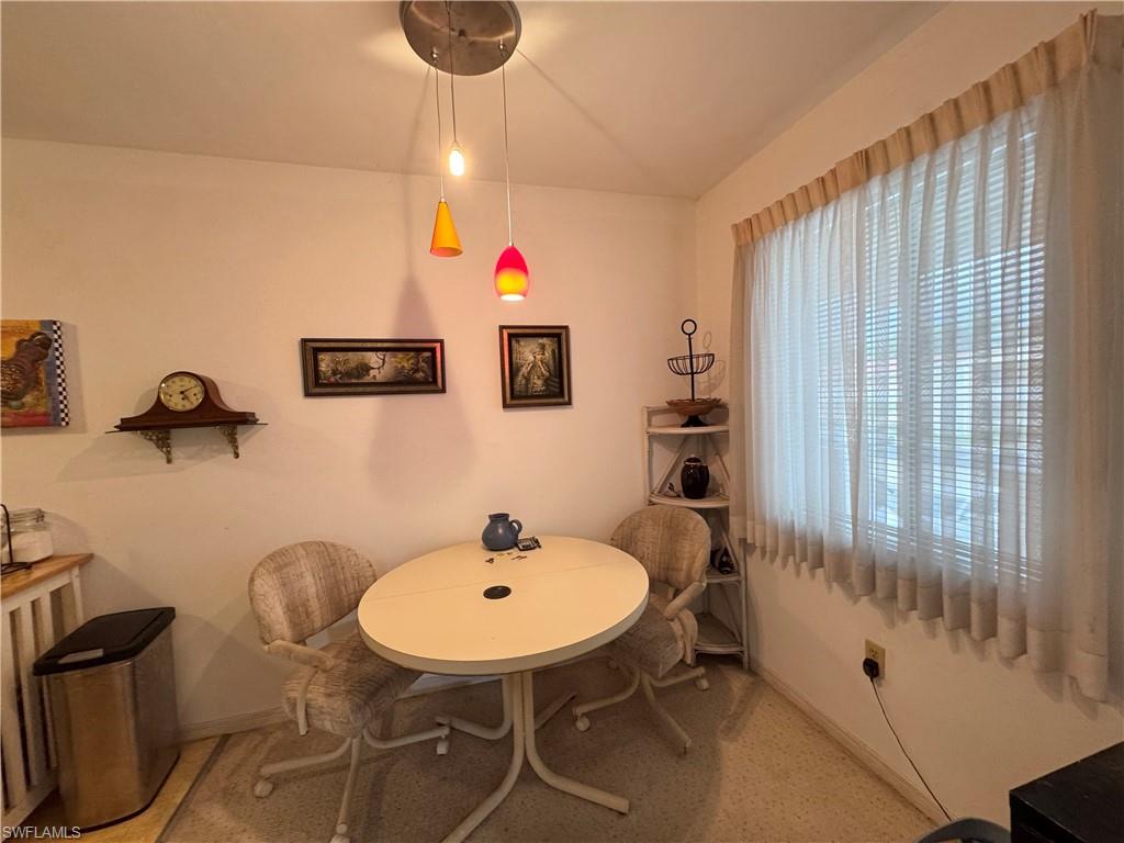 Dining room with lofted ceiling and light colored carpet