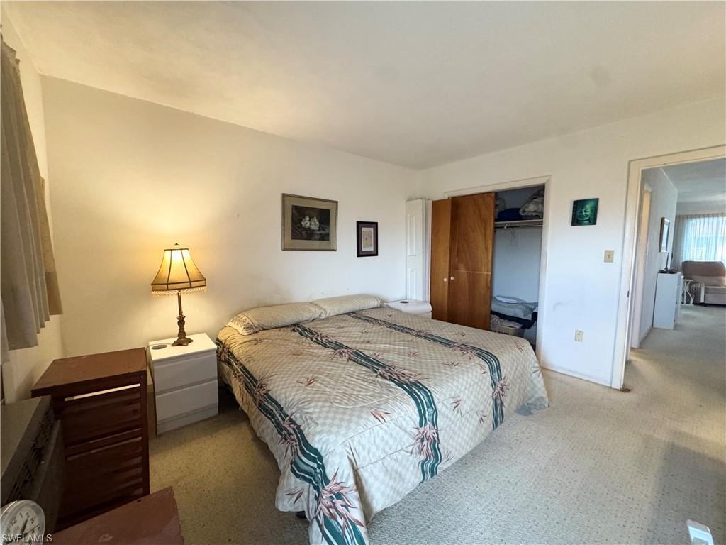 Bedroom featuring light colored carpet and a closet