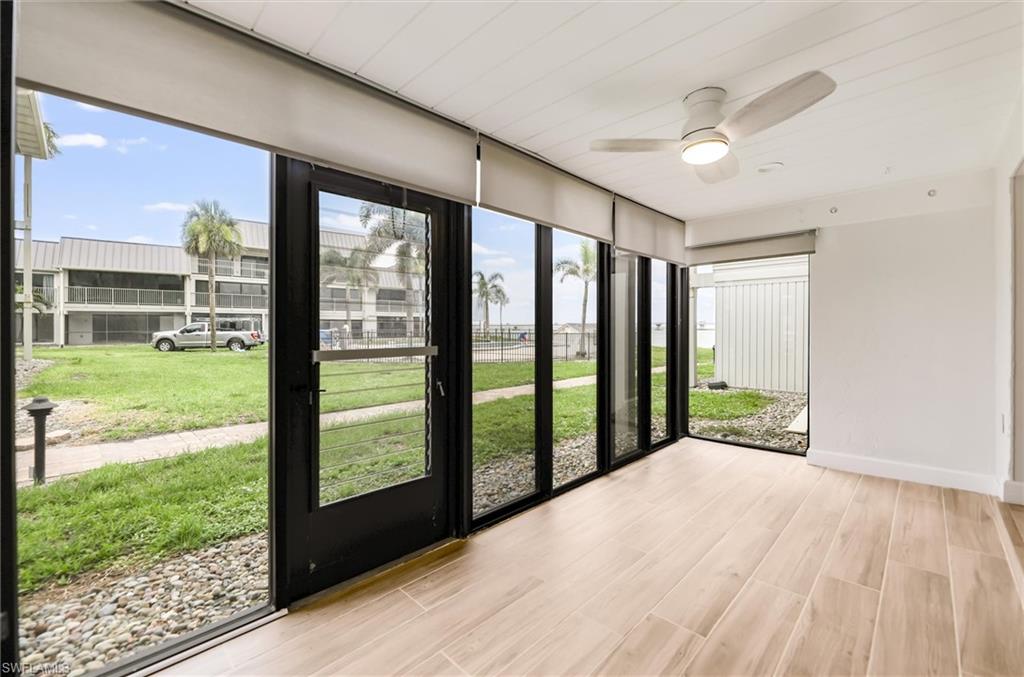 Unfurnished sunroom featuring plenty of natural light, ceiling fan, and wood finished floors