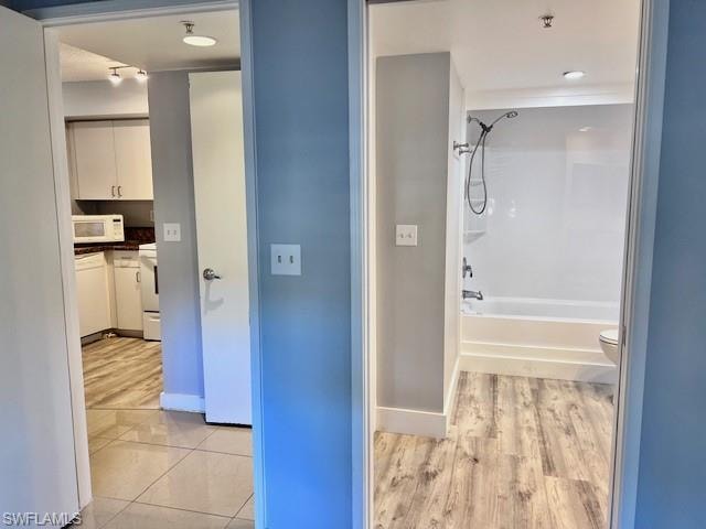 Bathroom featuring vanity,  shower combination, and wood finished floors