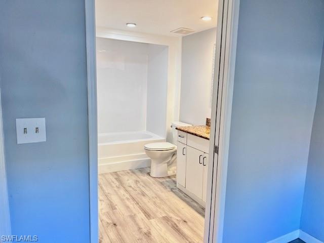 Bathroom with vanity, wood finished floors, and shower / bath combination