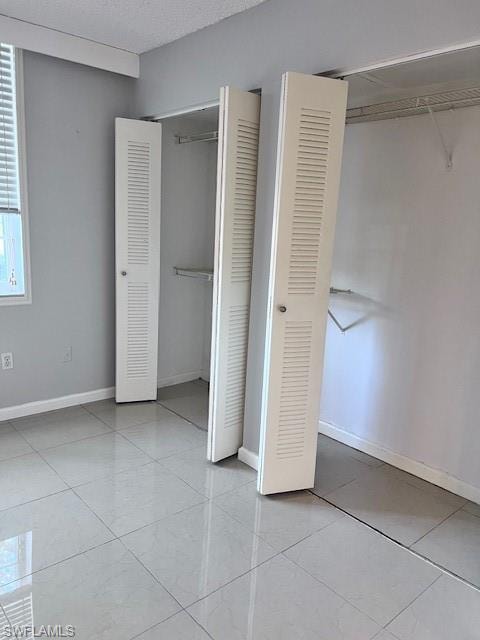 Unfurnished bedroom featuring baseboards and a textured ceiling