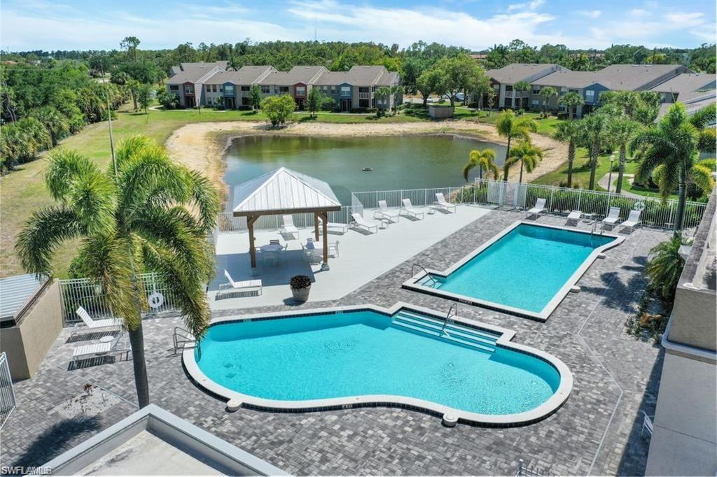 Community pool featuring a gazebo, a patio area, a water view, and a residential view