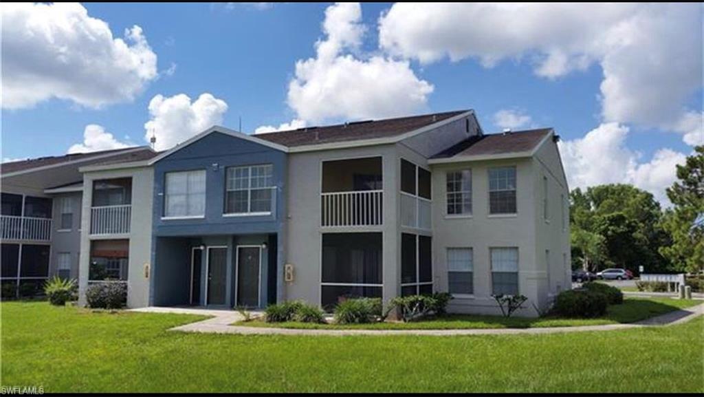 Rear view of property with stucco siding and a yard