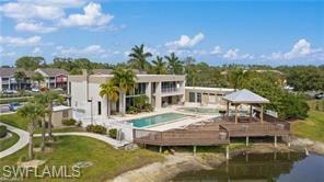 Rear view of property featuring a community pool and a water view