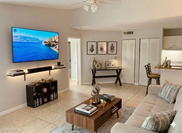 Living room featuring ceiling fan and light tile .patterned flooring.Staging