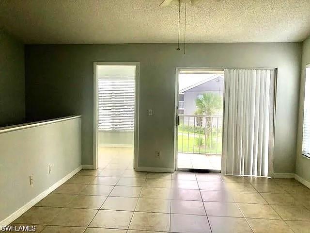 Unfurnished dining area with a textured ceiling, healthy amount of natural light, and light tile patterned floors