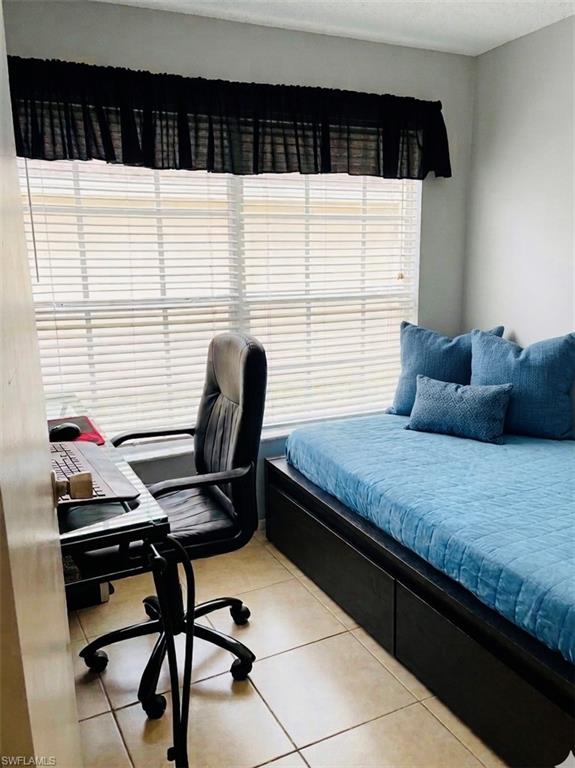 Bedroom with an office area and light tile patterned flooring