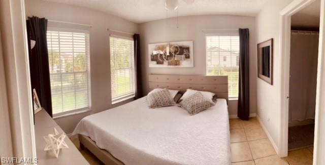 Bedroom with light tile patterned floors and multiple windows