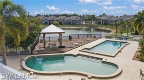 Community pool featuring a gazebo, a hot tub, a residential view, a water view, and a patio
