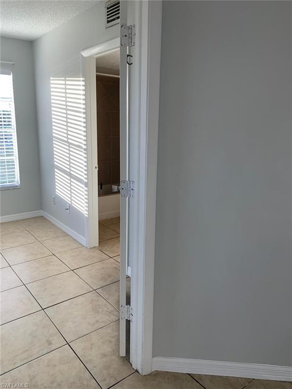 Spare room featuring light tile patterned floors and a textured ceiling