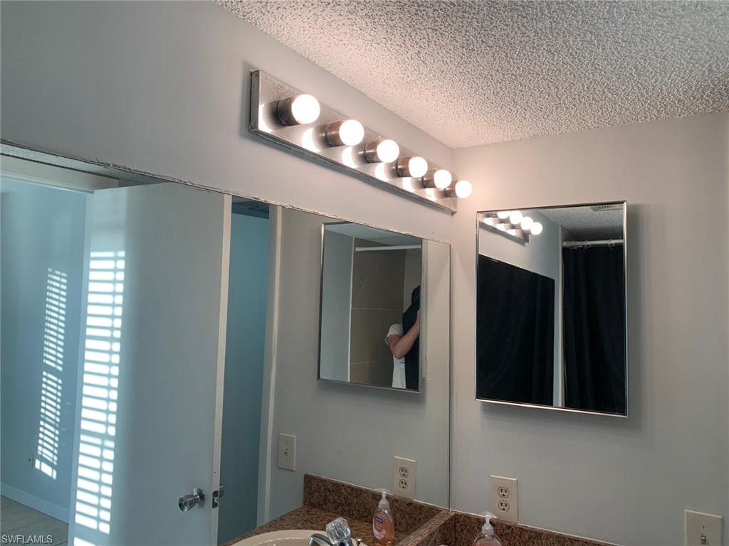 Full bathroom with a textured ceiling and vanity
