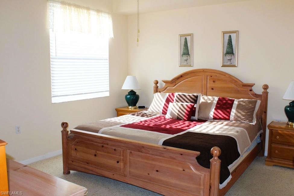 Carpeted bedroom featuring multiple windows