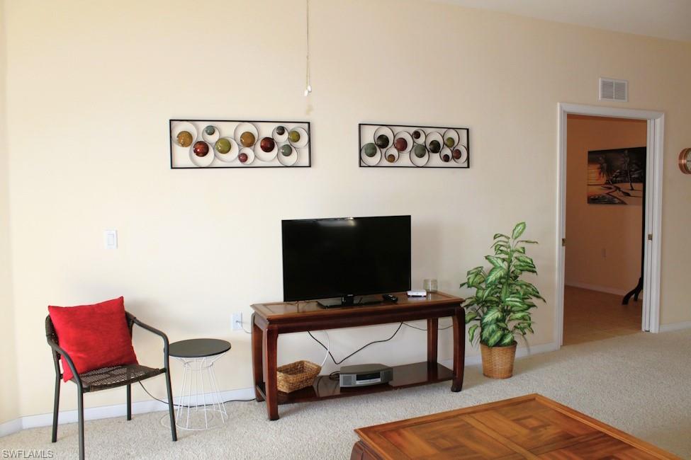 Carpeted living area with baseboards