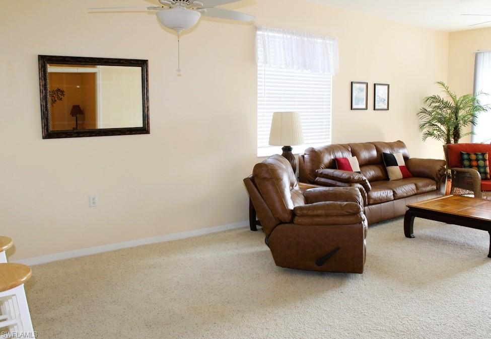 Living room featuring a ceiling fan and carpet floors