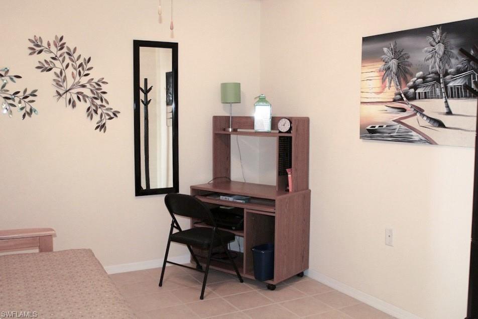 Office space with baseboards and light tile patterned flooring