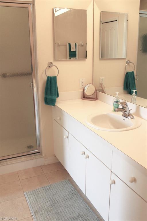 Bathroom with a shower stall, vanity, and light tile patterned floors