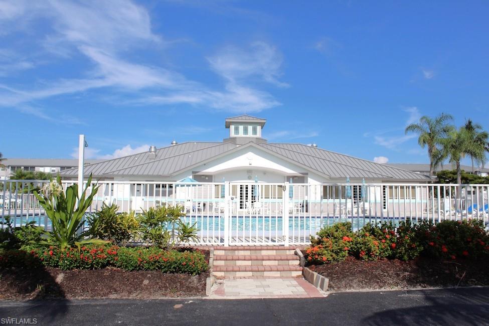 View of building exterior featuring a community pool