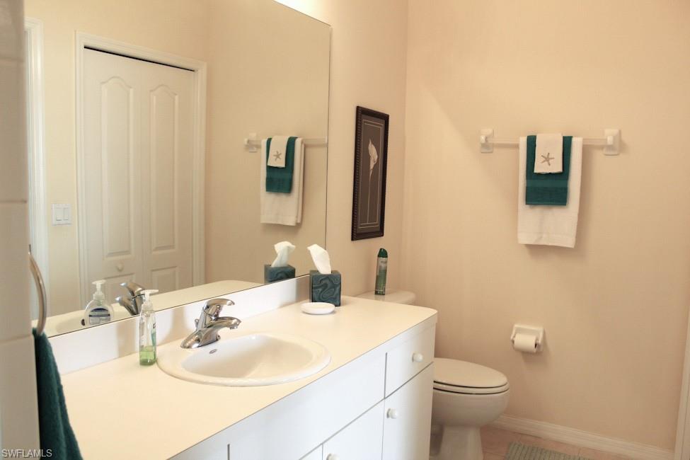 Bathroom with vanity, a closet, and light tile patterned floors