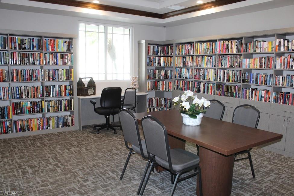 Office with wall of books and recessed lighting