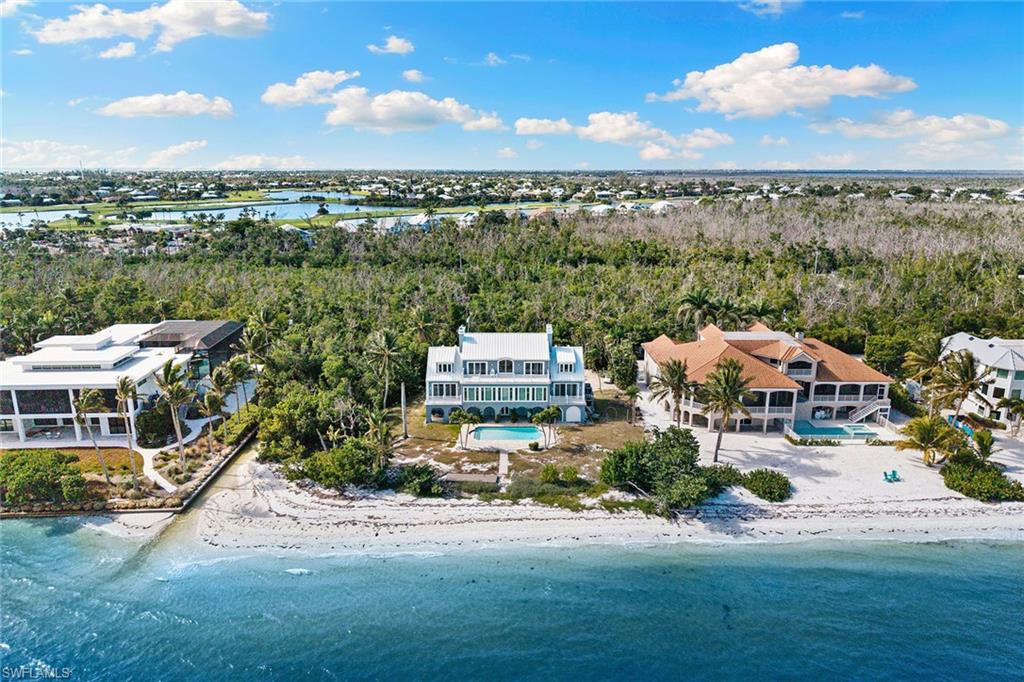 Aerial view of waterfront with a beach and a forest