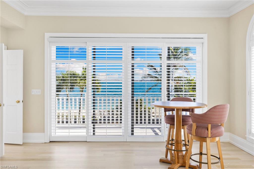Dining space with light wood-type flooring and crown molding