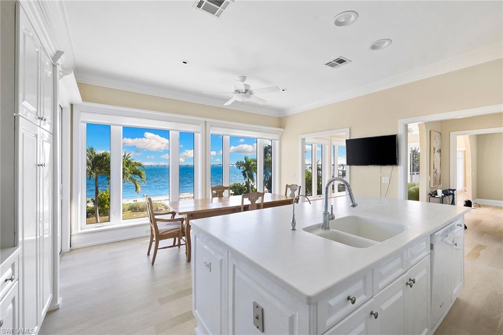Kitchen featuring white cabinets, plenty of natural light, light wood-style floors, crown molding, and recessed lighting