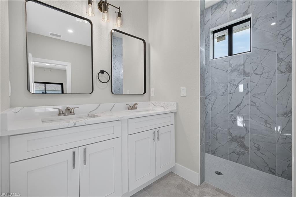 Spacious interior room featuring light-toned walls and large format tile flooring