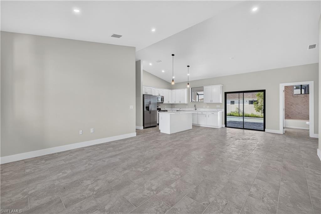 Spacious room featuring large format tile flooring, a black ceiling fan, and sliding glass doors that open to a screened-in pool area