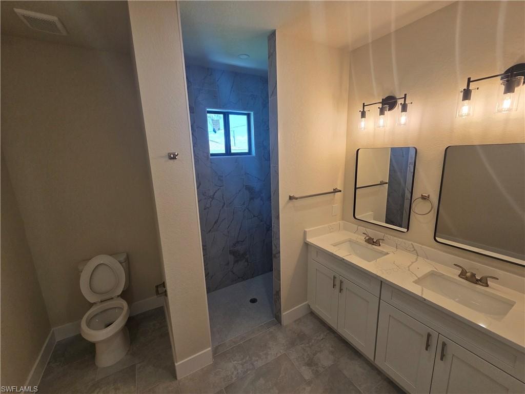 Double vanity with white cabinetry and integrated sinks, complemented by contemporary black-framed mirrors and industrial-style lighting