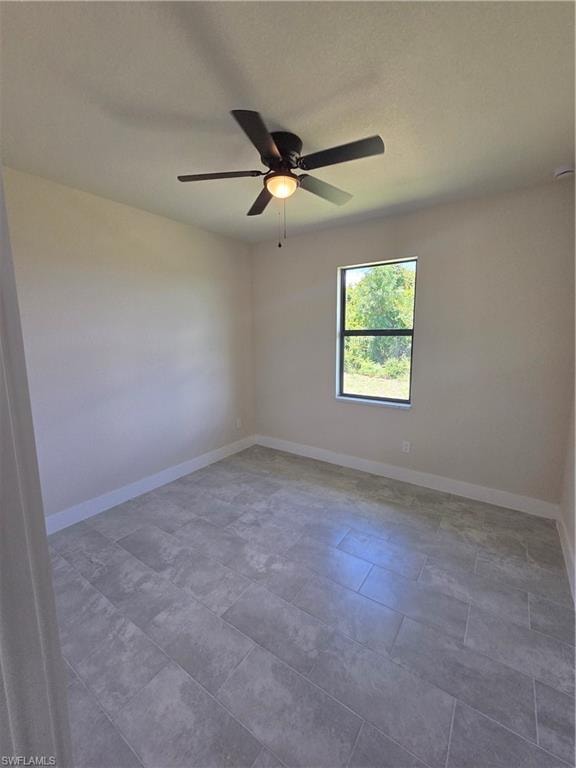 Spacious room featuring neutral wall tones, large format tile flooring, a ceiling fan with integrated lighting, and a window offering abundant natural light