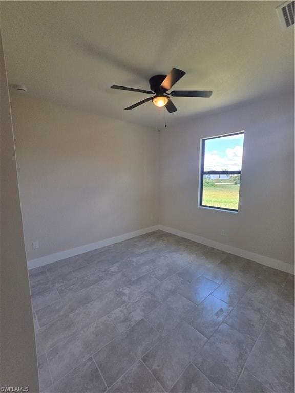 Spacious room featuring neutral tone walls, large format tile flooring, and a ceiling fan with integrated lighting