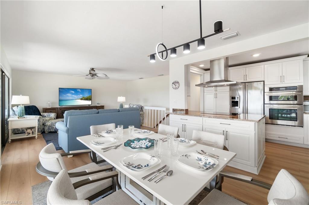 Dining space featuring light wood-style floors, ceiling fan, and recessed lighting