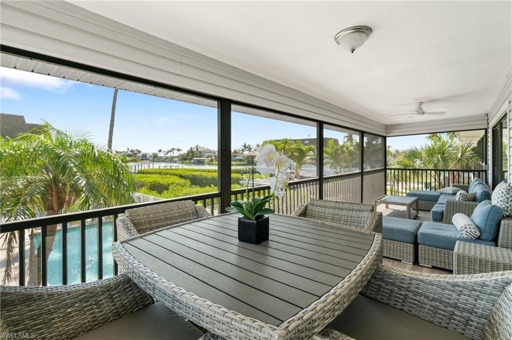 Sunroom with a ceiling fan, a water view, an outdoor living space, and outdoor dining area