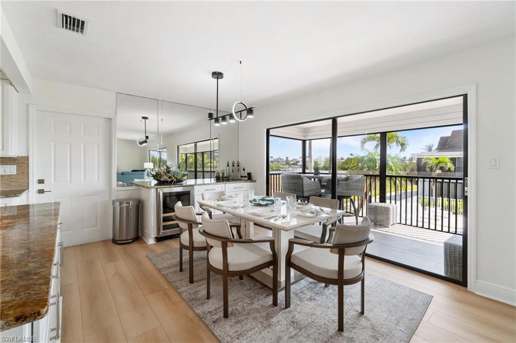 Dining space with beverage cooler and light wood-style floors