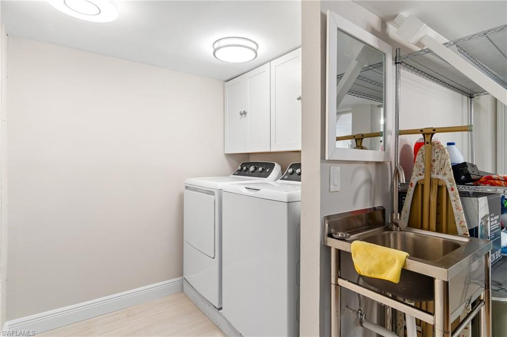Washroom featuring separate washer and dryer and cabinet space