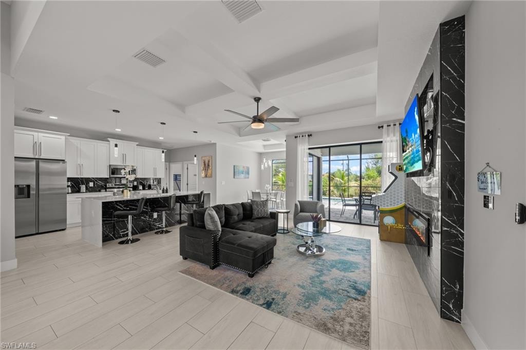 Living room featuring a ceiling fan, beamed ceiling, wood tiled floors, coffered ceiling, and recessed lighting