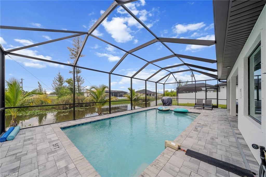 Swimming pool featuring a patio area, a water view, and a lanai