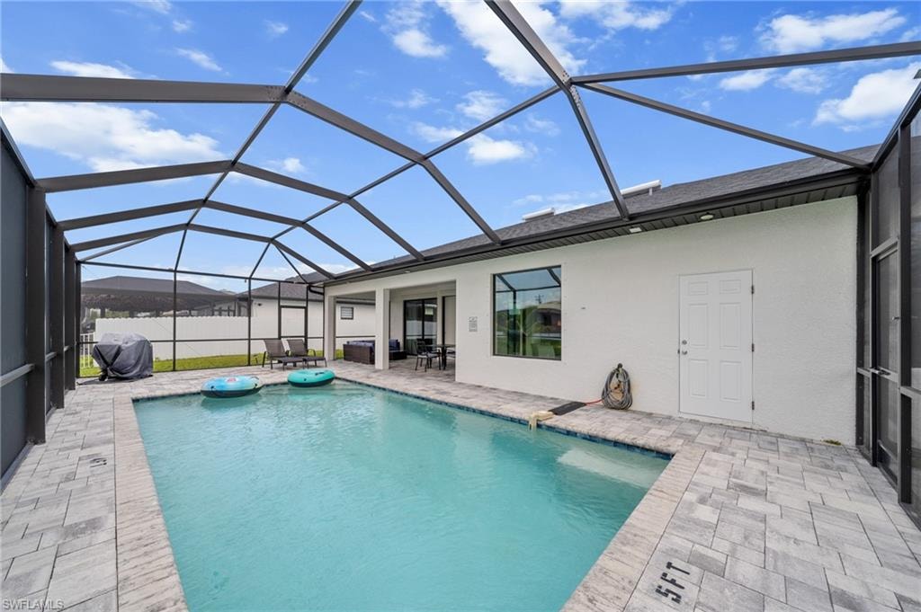 View of swimming pool featuring a patio and a lanai