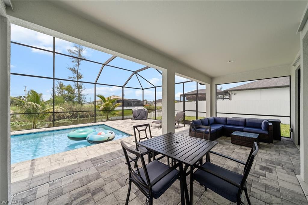 View of patio / terrace with an outdoor hangout area, an outdoor pool, and glass enclosure