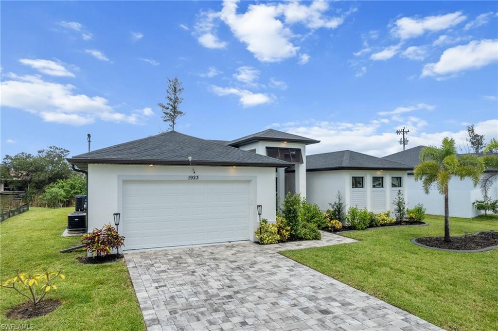 View of front of house with a garage, decorative driveway, stucco siding, and a shingled roof