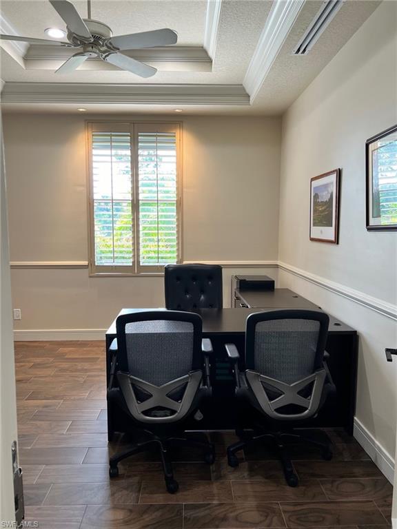 Office space featuring crown molding, a tray ceiling, a ceiling fan, a textured ceiling, and recessed lighting