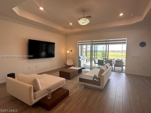 Living room featuring a raised ceiling and hardwood / wood-style floors