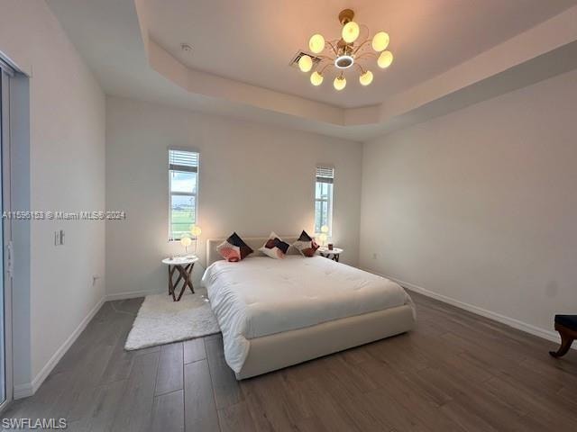 Bedroom with a raised ceiling and hardwood / wood-style floors