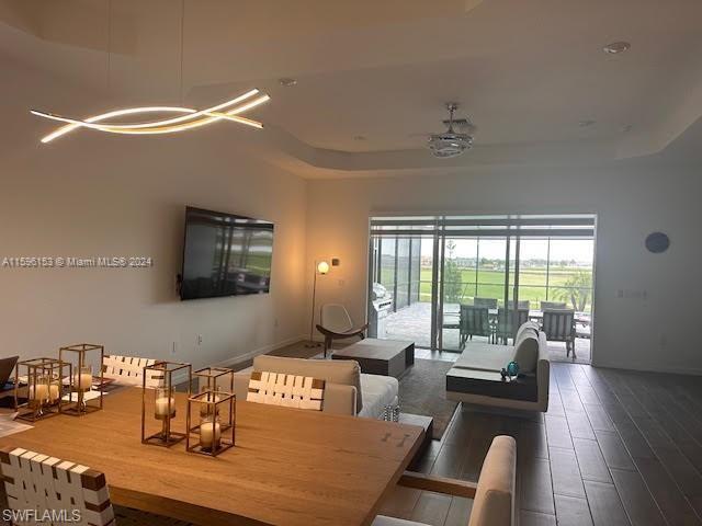 Dining area with a tray ceiling and wood-type flooring
