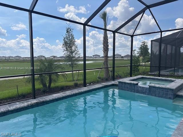 View of pool featuring an in ground hot tub and glass enclosure
