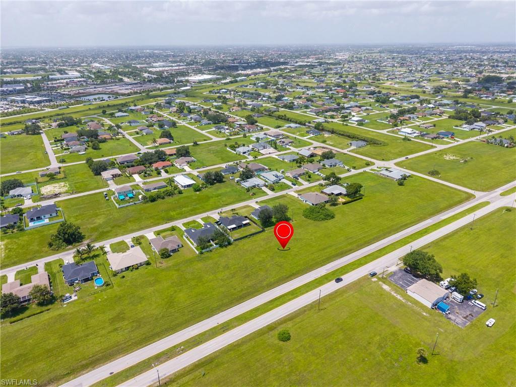 Aerial view of property and surrounding area featuring nearby suburban area