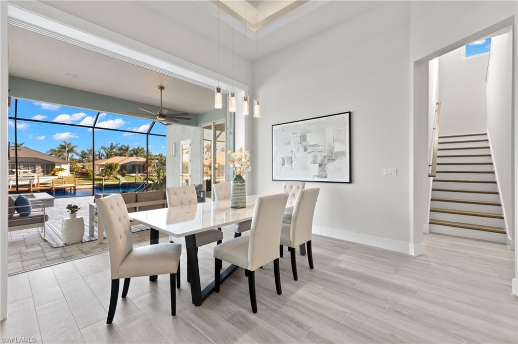 Dining space with a towering ceiling, light wood-type flooring, and ceiling fan