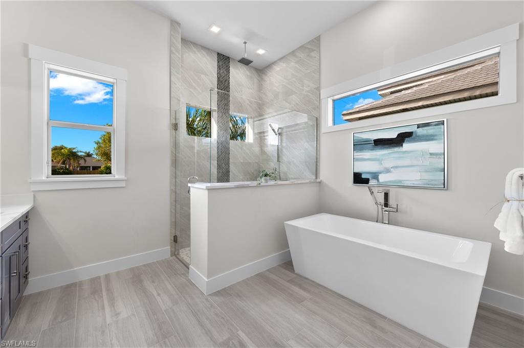 Bathroom with vanity, hardwood / wood-style flooring, and independent shower and bath
